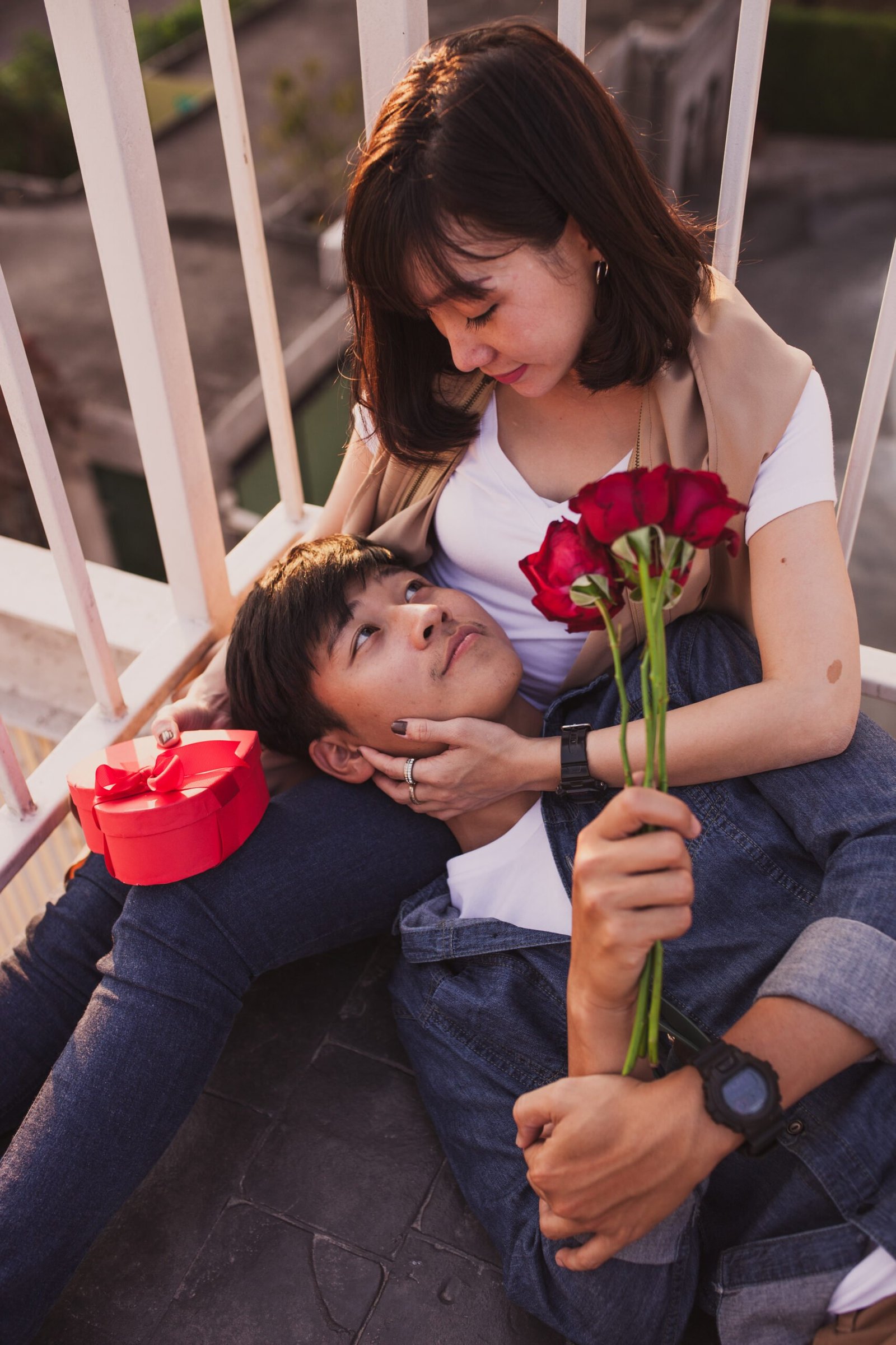 boy-lying-his-girlfriend-s-legs-with-roses-his-hand